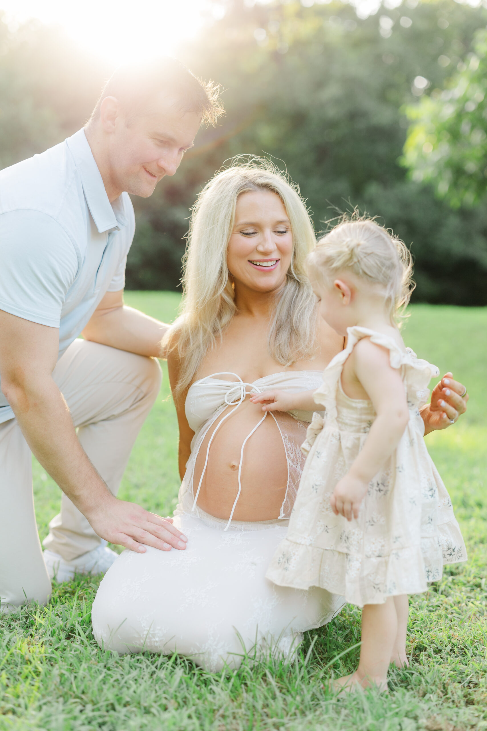 maternity family photos with toddler little girl touching moms belly at historic oak view county park in raleigh